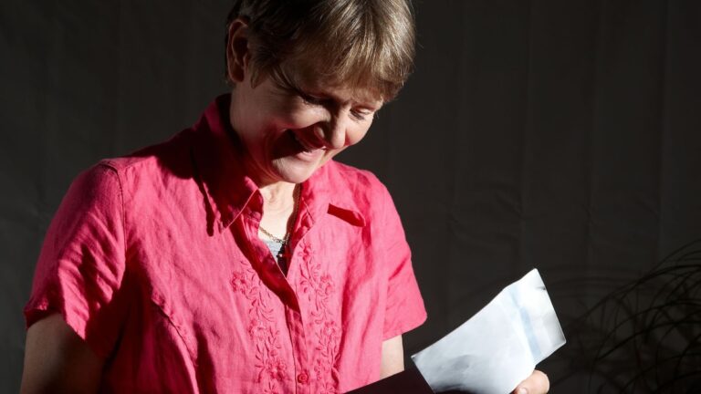 a woman smiling and holding a piece of paper for Tax debt abatement programs