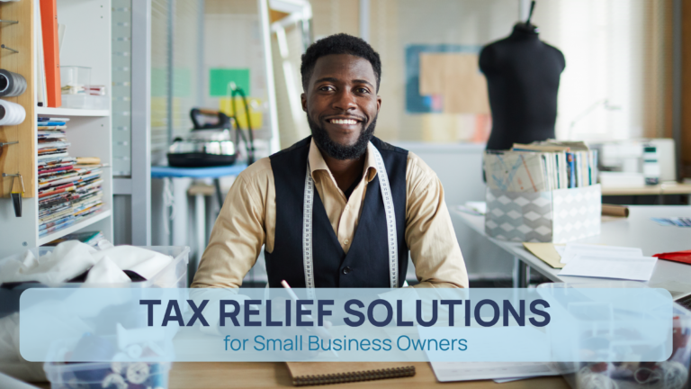 A smiling small business owner, dressed in a beige shirt and black vest with a measuring tape around his neck, sits at a desk in a tailor workshop. Behind him are sewing materials, fabric, and a mannequin. Overlay text reads 'Tax Relief Solutions for Small Business Owners.'